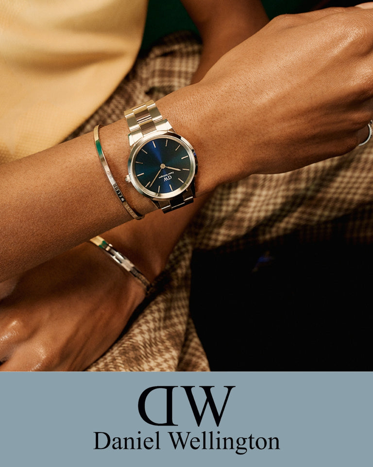 Daniel Wellington ur med stålrem og blå urskive på håndled, forside, stilfuldt og moderne design.