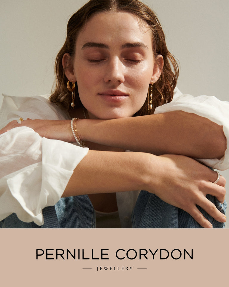 Pernille Corydon smykker model med guld øreringe og armbånd, forsidebillede, afslappet stil